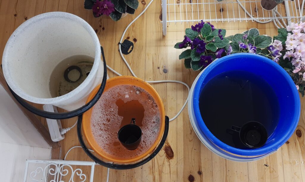 Kbelíky - použitá voda, voda na vypláchnutí zásobníku a kbelík s čerstvou vodou